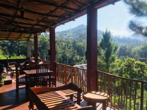 a porch with chairs and tables and a view of the mountains at Turn View Resort Ella in Ella