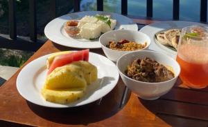a wooden table with plates of food and a drink at Free House Bentota in Bentota