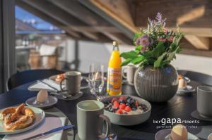 een tafel met eten en een fles bier en bloemen bij BergVibes in Garmisch-Partenkirchen
