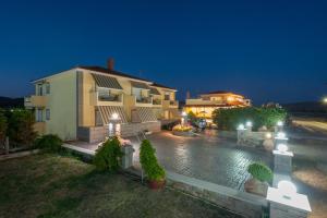 a house at night with a pool in front of it at Evgatis Hotel in Kondiás