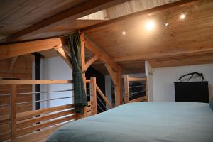a bedroom with wooden ceilings and a large bed at Pinéa Lodge - Chalet Authentique en Pin des Landes in Saint-Yaguen