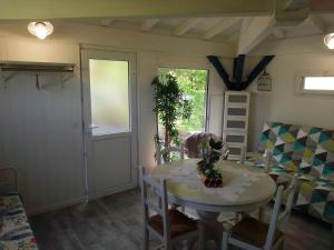 a room with a table and chairs and a window at Châlet en Gascogne in Vergoignan