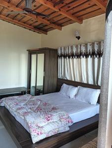 Un dormitorio con una cama con cabecero de madera. en Ghorakhal Homestay, en Nainital