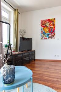 a living room with a table and a painting on the wall at Industriecharme Apartment - Nespresso, Netflix, WIFI, Zentral, Messe in Chemnitz