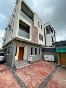 a house with a car parked in front of it at Lama Apartment & Suites in Ikeja