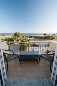 a balcony with a table and chairs and the ocean at Evgatis Hotel in Kondiás +18 photos