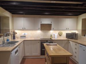 a kitchen with white cabinets and a counter top at Keeper’s Cottage in Montacute