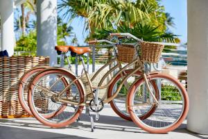 a bike with baskets parked next to a building at AC Hotel by Marriott Fort Lauderdale Beach in Fort Lauderdale