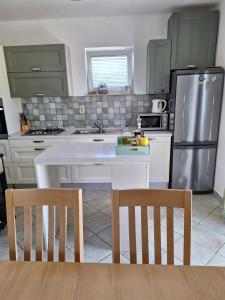a kitchen with a refrigerator and a table and chairs at Holiday Home Sea & River Pearl in Komin