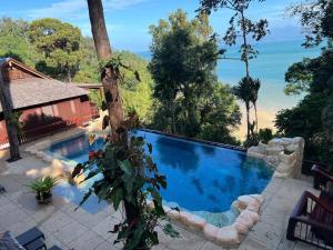 a swimming pool with a view of the beach at Hidden Paradise Private Villa 2, Langkawi in Teluk Datai