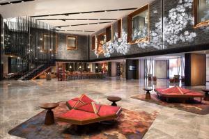 西安市にあるRenaissance Xi'an Hotelのテーブルと椅子のあるホテルのロビー