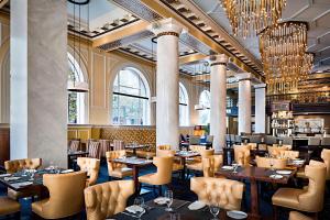a restaurant with tables and chairs and chandeliers at Hotel ICON, Autograph Collection in Houston