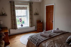 una camera da letto con un letto grande e una finestra di Mill Cottage a Clitheroe