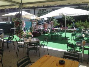 an outdoor patio with tables and chairs and umbrellas at Alice Affittacamere in Cesana Torinese
