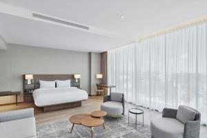 萨尔蒂约AC Hotel by Marriott Saltillo的一间带一张床和两把椅子的酒店房间
