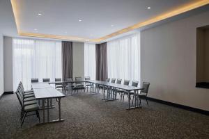 萨尔蒂约AC Hotel by Marriott Saltillo的一间会议室,配有长桌子和椅子以及窗户