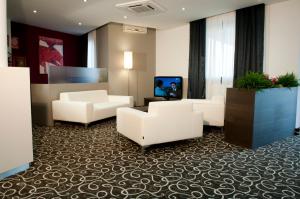 a lobby with couches and a tv in a building at Hotel Gardenia in Romano Canavese