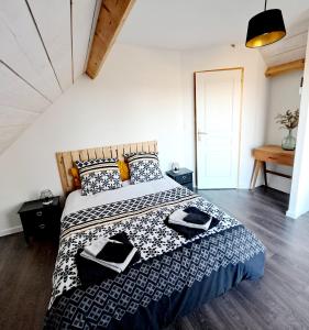 ein Schlafzimmer mit einem Bett mit einer schwarz-weißen Bettdecke in der Unterkunft La maison au bout du chemin in Poey-dʼOloron + 26 Fotos