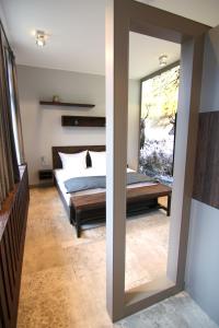 1 dormitorio con cama y espejo grande en StrandBerg's Designhotel Viktoria en Braunlage