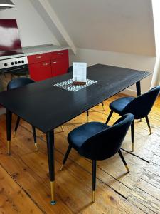 曼海姆Quadrate Hostel Mannheim Z5 Denkmalschutz的厨房里一张带四把椅子的黑桌
