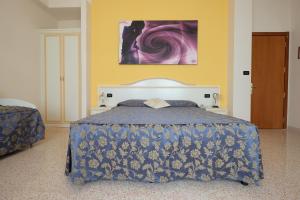 a bedroom with a bed with a blue comforter at Hotel Mazzocca in Caramanico Terme