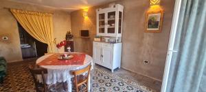 a room with a table and a kitchen with a table and chairs at La Dimora dellaZingara in Statte