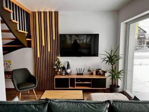 a living room with a couch and a television at Osiedlowa 7 in Tylicz