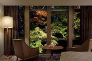 a room with a large window with a bed and a table at The Prince Kyoto Takaragaike, Autograph Collection in Kyoto