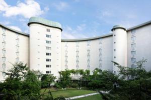 a large white building with two towers at The Prince Kyoto Takaragaike, Autograph Collection in Kyoto
