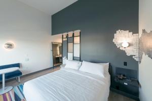 a bedroom with a white bed and a desk at Aloft San Antonio UTSA Area in San Antonio +18 photos