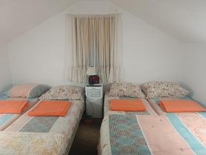 two twin beds in a room with a window at Privatni smještaj Kurtalija in Jajce