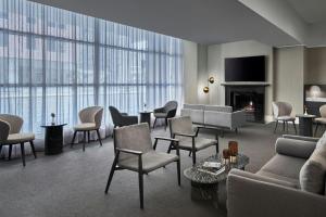 ein Wohnzimmer mit Sesseln, Sofas und einem Kamin in der Unterkunft Melbourne Marriott Hotel in Melbourne