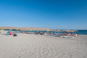 a beach with many chairs and umbrellas and the ocean at Evgatis Hotel in Kondiás
