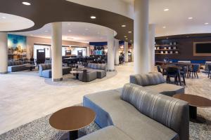 デイニア・ビーチにあるCourtyard by Marriott Fort Lauderdale Airport & Cruise Portのソファとテーブルのあるロビー、レストランを併設しています。