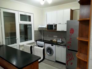 a kitchen with a refrigerator and a stove top oven at Apartment for rent number 2 in Aktau +4 photos