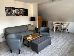 a living room with a couch and chairs and a table at Ferienwohnung in Erfurt Marbach (Maisonette) in Erfurt