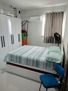 a small bedroom with a bed and a blue chair at Apto Pedreira para círio e cop30 in Belém