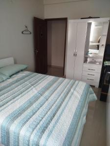 a bedroom with a bed with a blue and white bedspread at Apto Pedreira para círio e cop30 in Belém