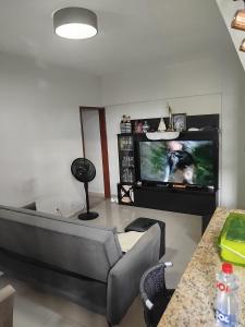a living room with a couch and a flat screen tv at Apto Pedreira para círio e cop30 in Belém