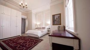 Un dormitorio con una cama y una mesa y una ventana. en Villa Antica, en Ciudad del Cabo 59 fotos más