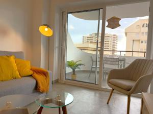 a living room with a couch and a glass table at Modern & sunny beach apartment in Fuengirola