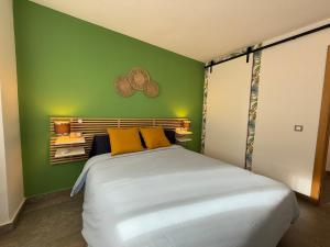a green bedroom with a large bed with yellow pillows at Modern & sunny beach apartment in Fuengirola +13 photos
