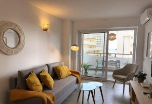 a living room with a couch and a table at Modern & sunny beach apartment in Fuengirola