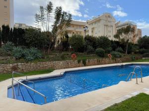 a large swimming pool in front of a building at Modern & sunny beach apartment in Fuengirola
