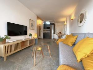 a living room with a couch and a flat screen tv at Modern & sunny beach apartment in Fuengirola