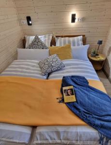 a bed with a book on it in a room at Tiny House Lotta - Auszeit-Oase am Plauer See in Stuer