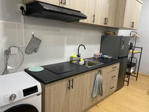 a small kitchen with a sink and a refrigerator at FUMY Homestay in Kuantan