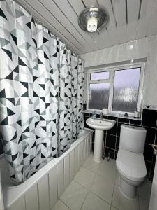 un baño con inodoro y lavabo en 3 Bedroom House Available, en Hounslow