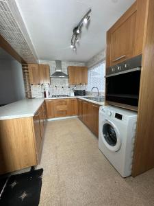 una cocina con lavadora y lavadora en 3 Bedroom House Available, en Hounslow
