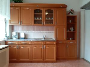 a kitchen with wooden cabinets and a sink at Apartman Veiger4 in Siófok